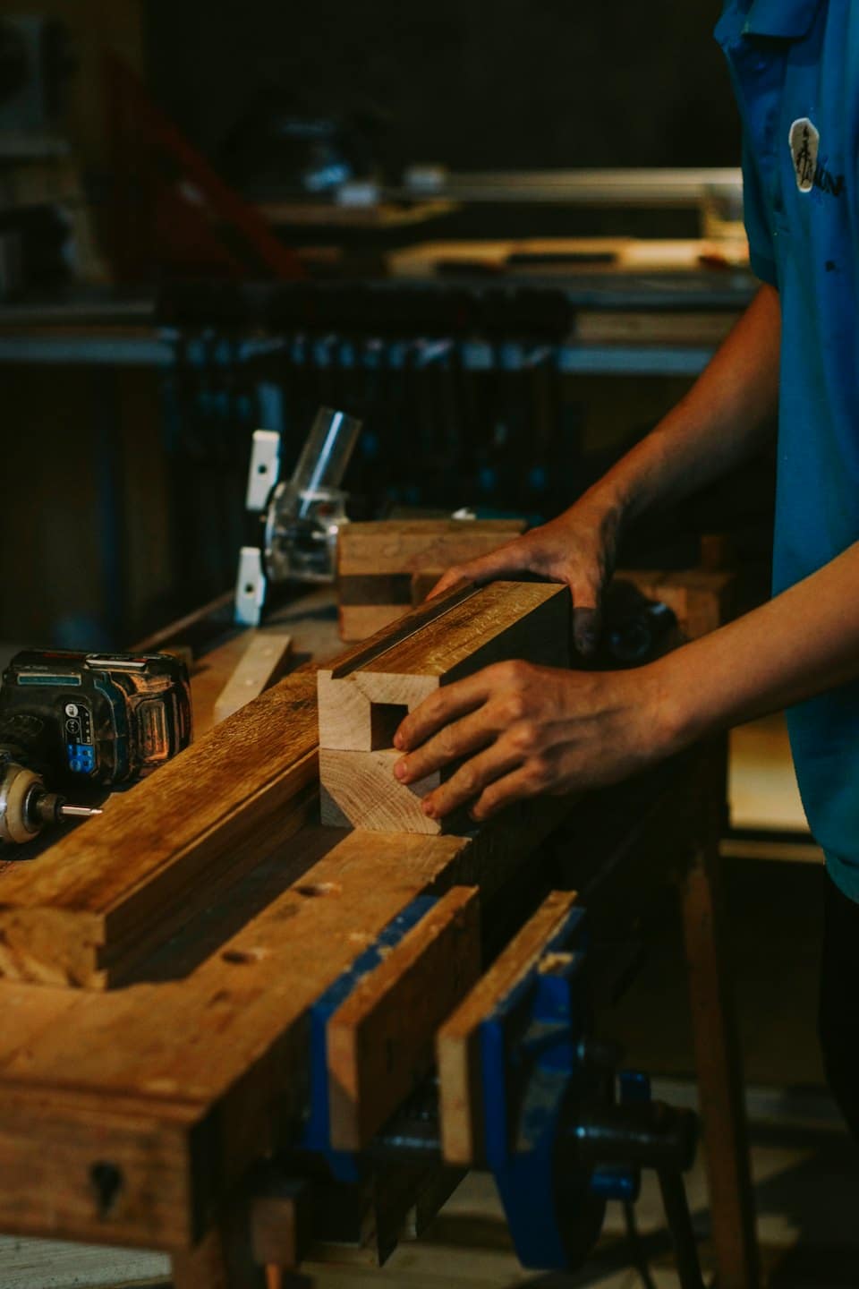 Falegname che incastra un giunto di legno su un banco da lavoro.
