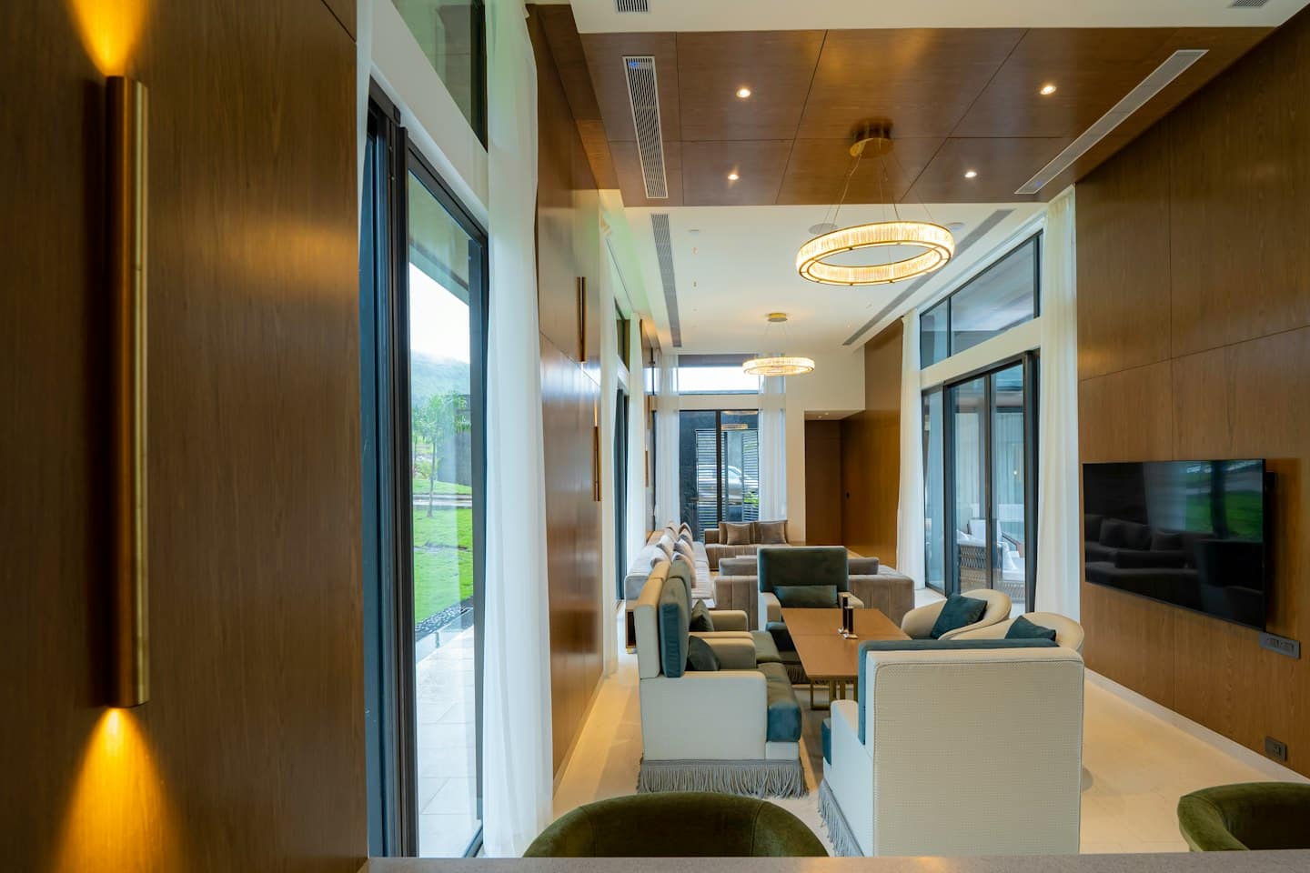 Moderna zona lounge con mobili contemporanei e grandi finestre che si affacciano sulle colline.
